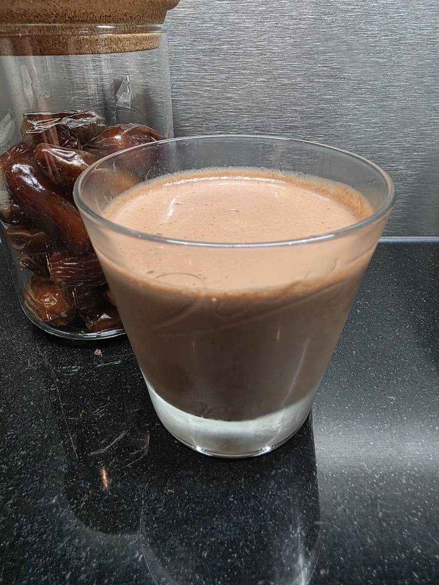 Mousse chocolat dattes et chia servie dans un verre à côté d'un bocal de dattes Medjool